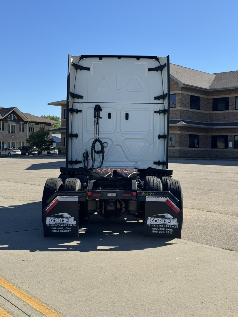 Rear view of a Freightliner Cascadia 126 tractor showing the back of the cab and dual rear tires with mud flaps.