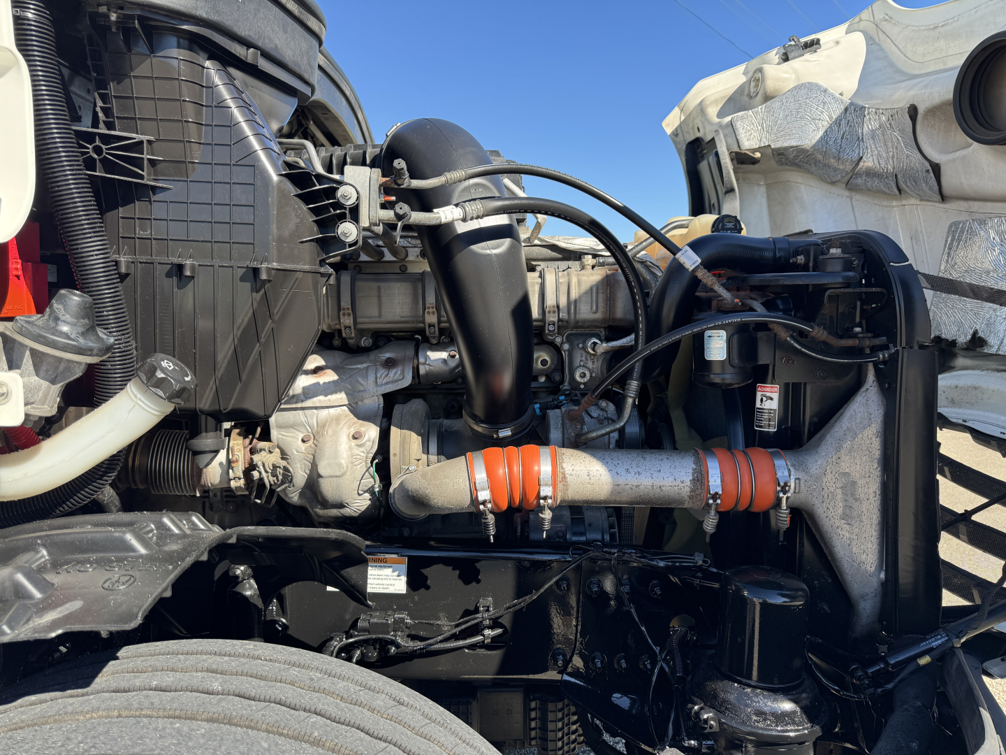 Volvo? No Freightliner Cascadia engine bay showing intake, hoses, and radiator with orange hose clamps.
