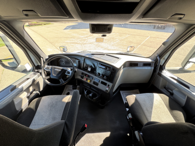 Freightliner Cascadia 126 cab interior showing steering wheel, dashboard, and center console with gauges and controls.