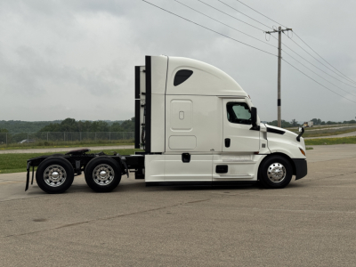 Freightliner Cascadia 126 sleeper cab truck side view showing chassis and tractor with white paint.