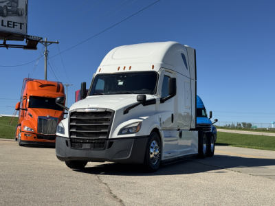 Truck cab side view showing Freightliner Cascadia 126 with white exterior in a dealership lot.