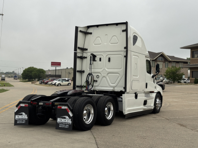 Truck cab and rear view showing sleeper tractor with tri-axle rear wheels, white exterior, Freightliner Cascadia 126, back of cab and chassis visible.