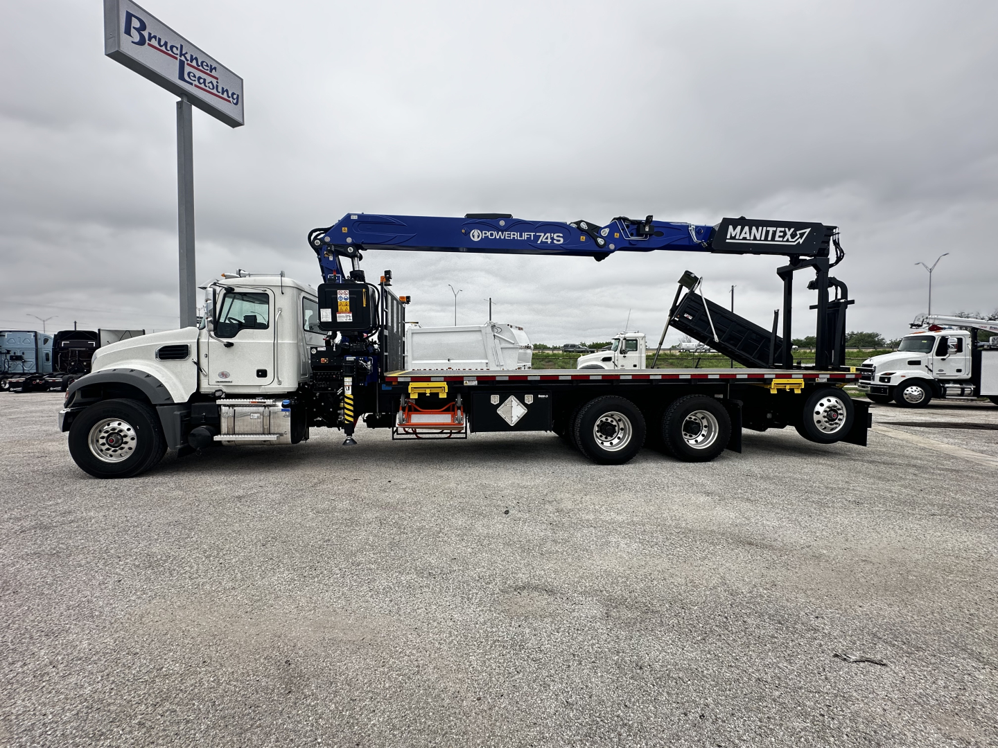 Truck-mounted tow/haul crane on Mack GR64F cab and chassis showing Manitex crane and hydraulic boom