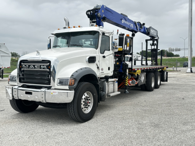 Mack GR64F cab and chassis truck with blue crane/loader on a flatbed, front grille with MACK badge, and white cab.