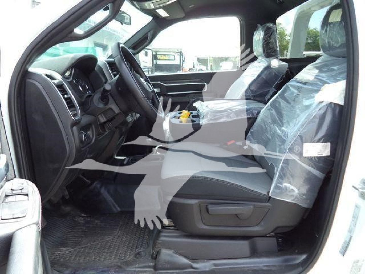 Ram 4500 SLT interior view showing front seats with plastic protective covers and dashboard in driver side angle.