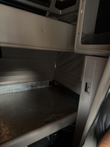 Truck cab interior of a Peterbilt 389 sleeper showing cabin entry area and lower cargo space.