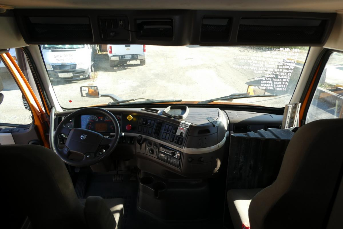 Volvo VNM cab interior showing steering wheel, dashboard, and driver’s seat in view.
