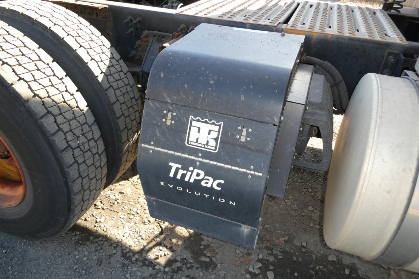 TriPac Evolution undertray with logo on a Volvo truck showing exhaust and rear tire, diesel truck chassis components visible.