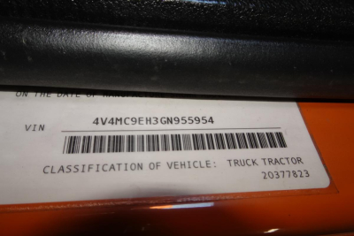 VIN tag visible on orange vehicle showing VIN 4V4MC9EH3GN955954 and classification ‘TRUCK TRACTOR’ with barcode.