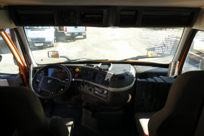 Volvo VNM cab interior showing steering wheel, dashboard, and driver’s seat in view.