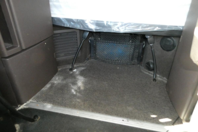 Volvo VNM sleeper cab interior showing storage area under bunk with netting and carpeted floor