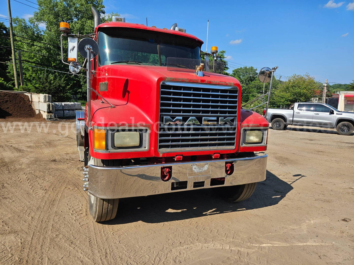 Front view of a red 2003 Mack CH613 truck showing chrome bumper, large grille, headlights, and side mirrors.