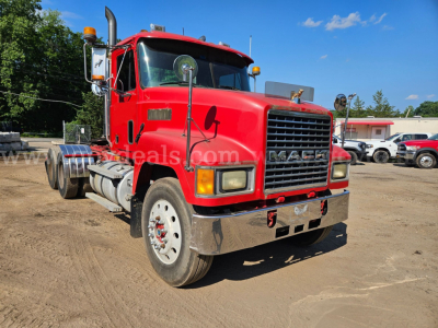 Mack CH613 heavy truck red cab front view showing chrome bumper, grille, mirrors, and dual rear axles.