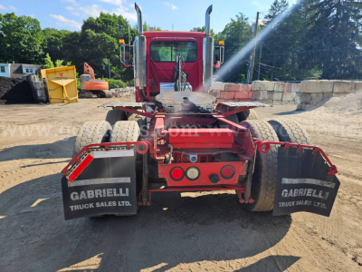 Rear view of a red Mack CH613 truck tractor showing dual rear axles, mud flaps labeled GABRIELLI TRUCK SALES LTD, and a fifth wheel with surrounding hydraulic lines.