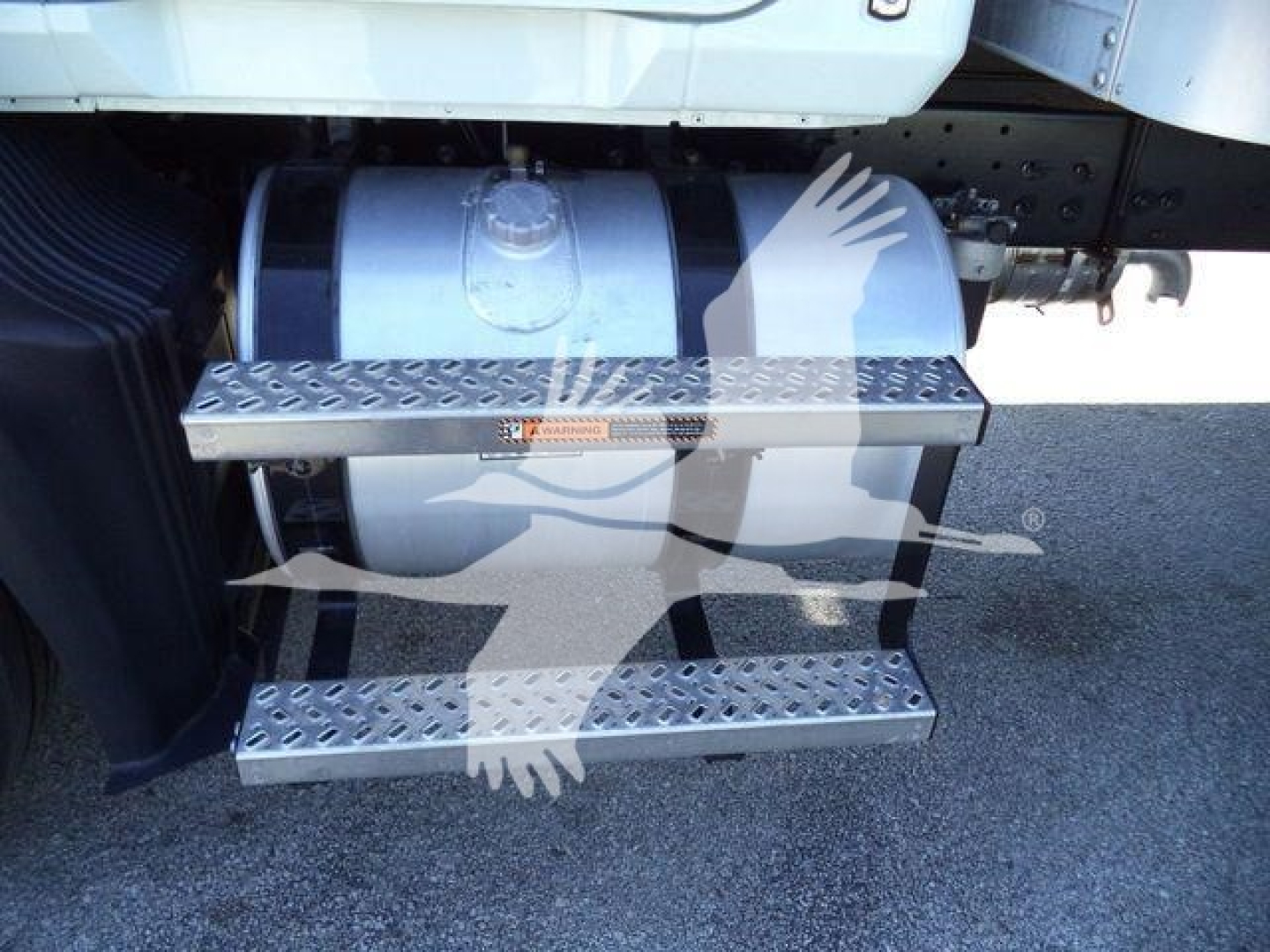 Truck side stairs with diamond plate steps and fuel tank visible under the cab.