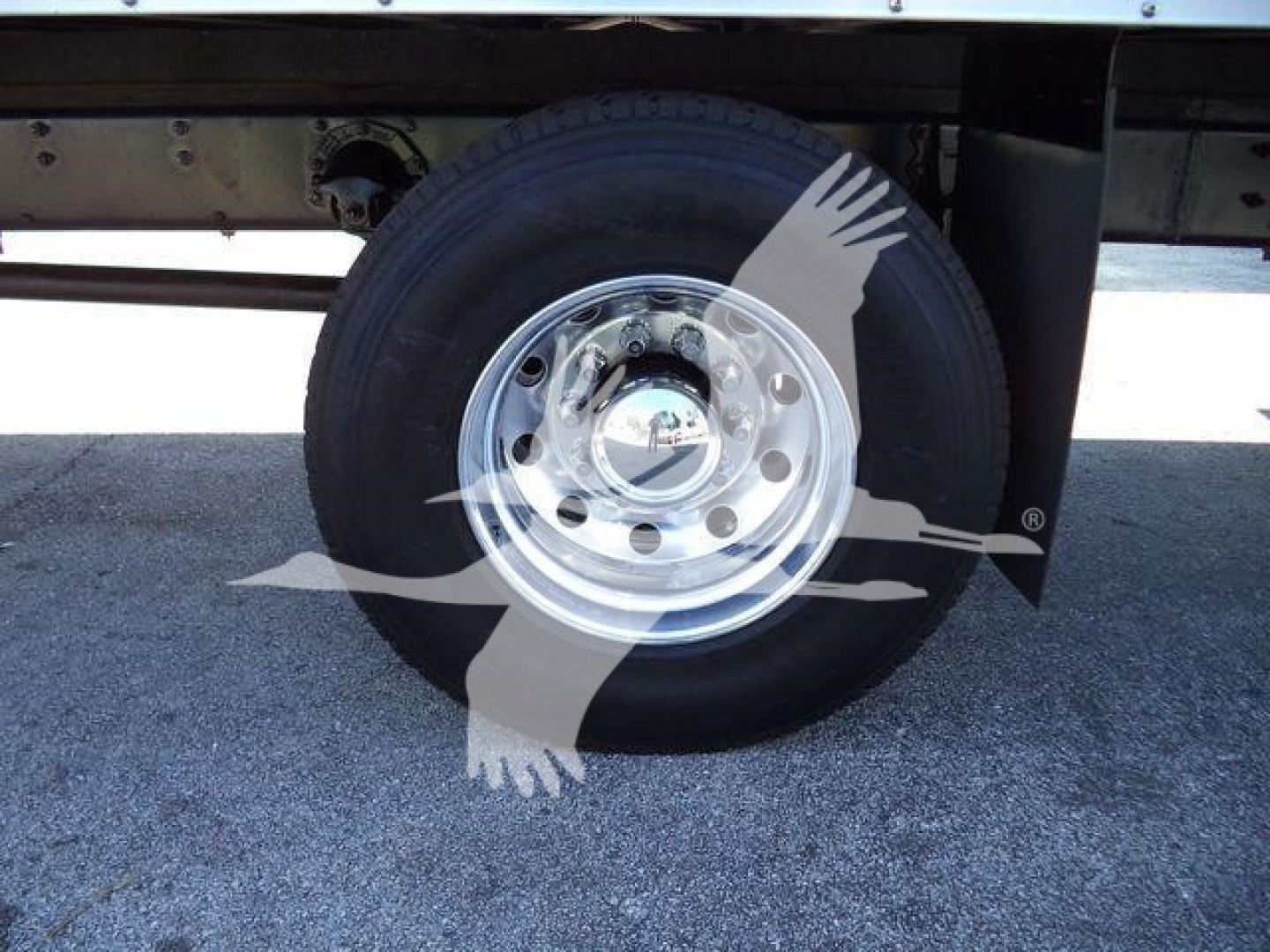 Truck wheel and hub of a new Mack MD6 box truck showing steel rim and tire. No visible text on components.