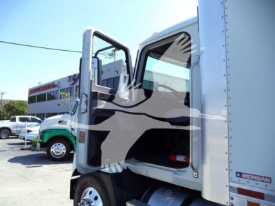 Box truck cab open door showing interior, 2026 Mack MD6 in-service truck body with green accents visible in background.