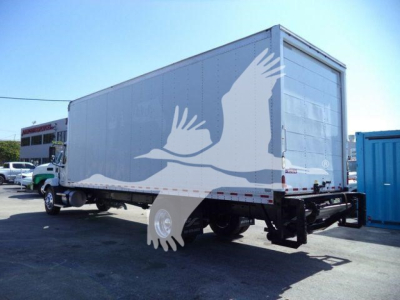 Box truck trailer attached to semi tractor with MD6 model; side and rear doors visible; empty stock image.