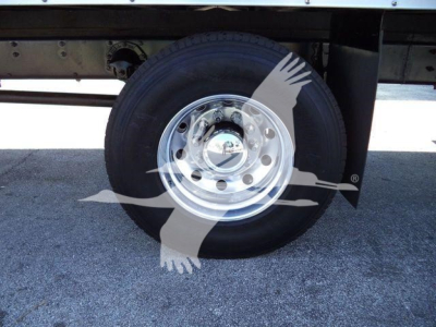 Truck wheel and hub of a new Mack MD6 box truck showing steel rim and tire. No visible text on components.