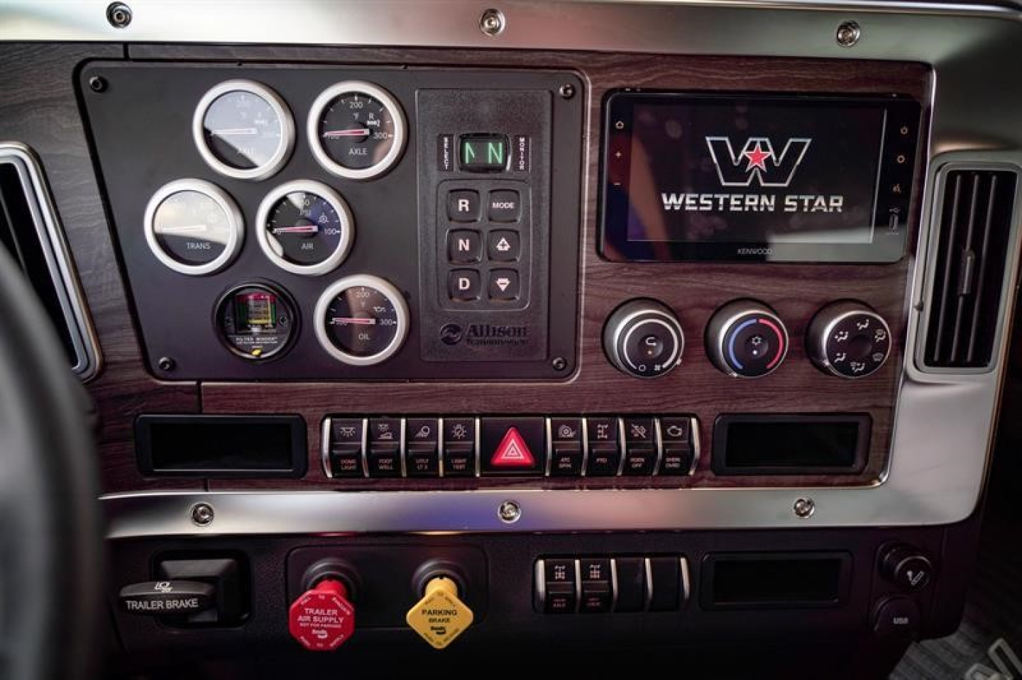 Dashboard and instrument cluster of a new Western Star 47X dump truck showing gauges, digital screen with Western Star logo, and control switches.