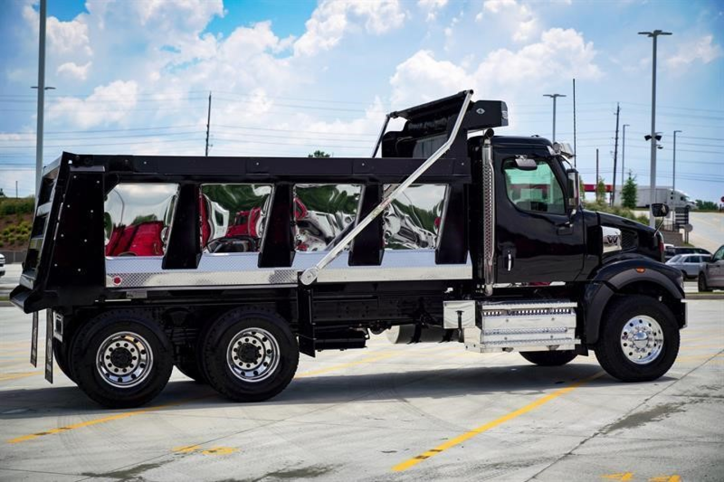 Western Star 47X dump truck in profile showing black cab and dump body with side guards and hydraulic hoist.