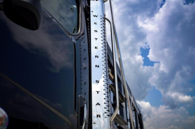 Western Star 47X dump truck side mirror and cab exterior with vertical chrome exhaust stack showing 'WESTERN STAR' lettering