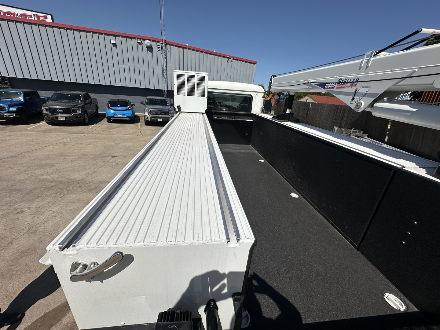 Truck bed of a new 2026 Mack MD7 service/utility truck showing aluminum cargo deck and side rails.