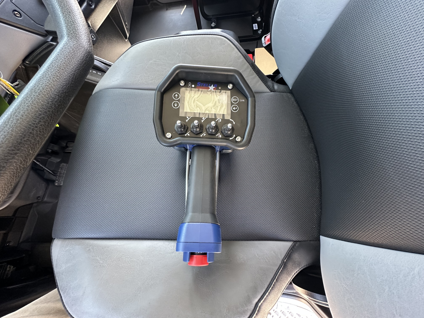 Mack MD7 vehicle interior with control panel mounted on a stalk between seats showing digital display and knobs.