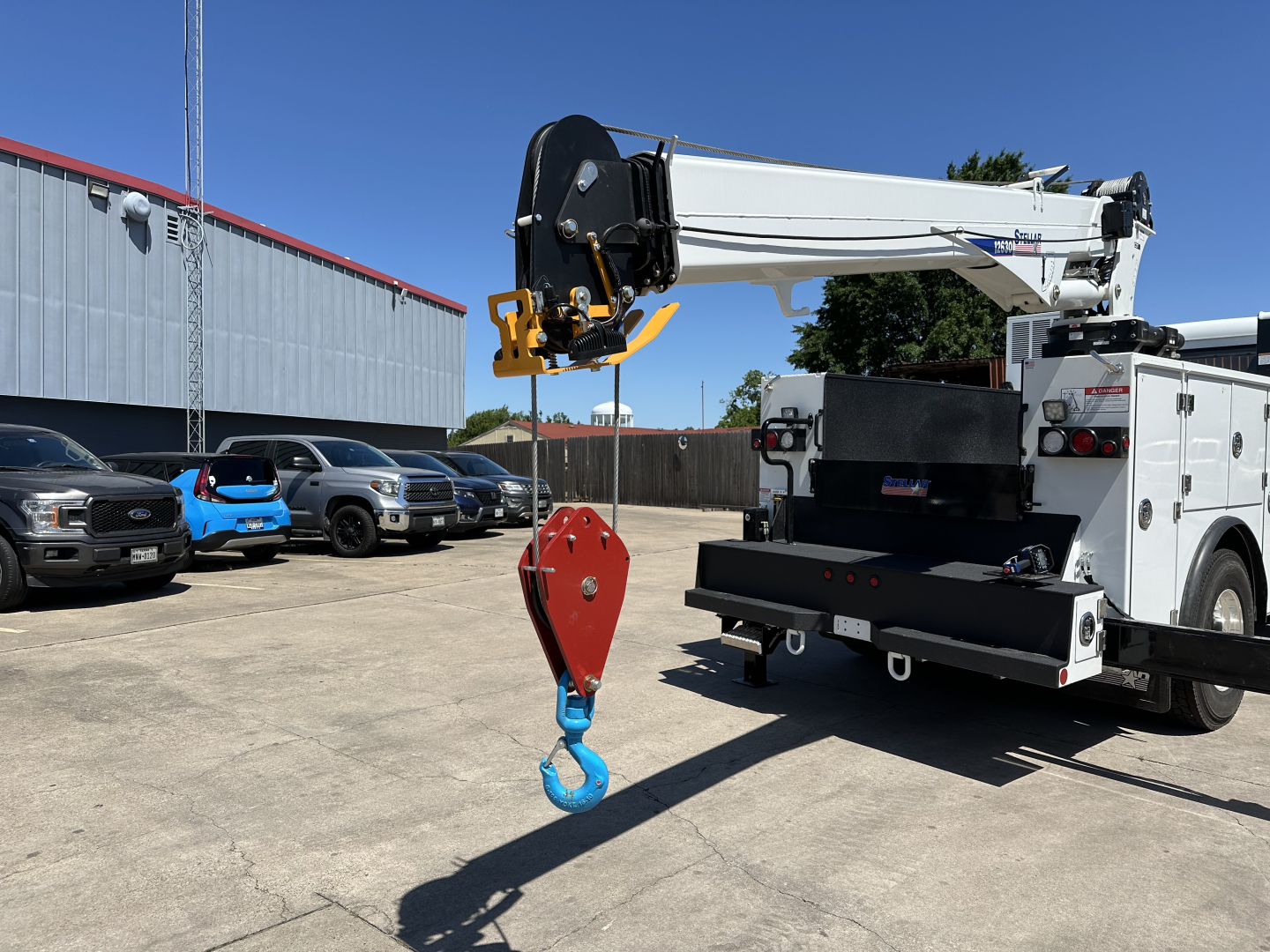 Mack MD7 service truck crane arm with hook, rear toolbox and crane jib visible.