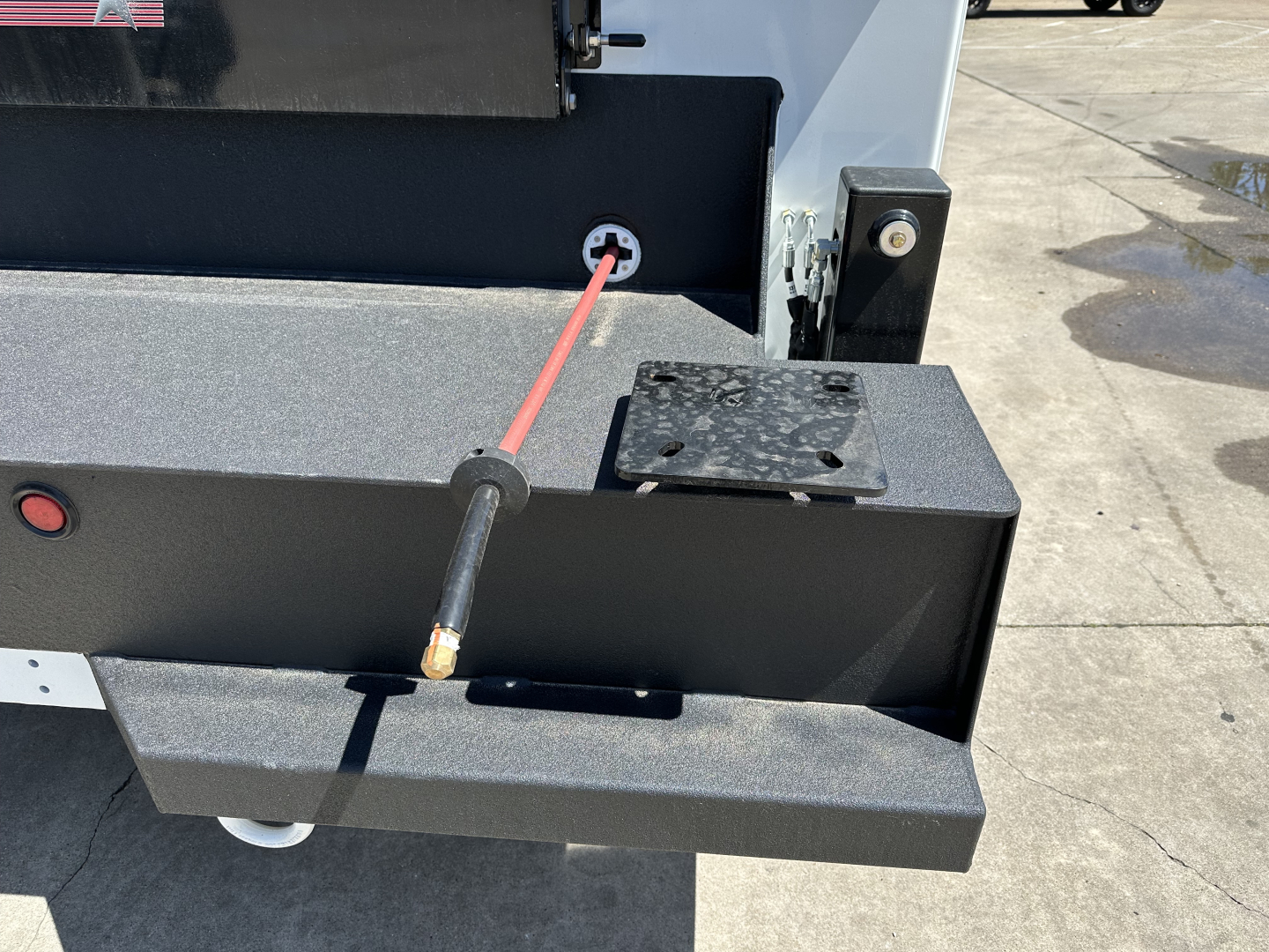 Mack MD7 service truck rear view showing hydraulic filler port and black metal bumper with red/black hose attached
