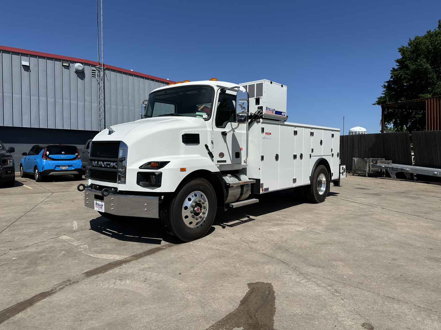 Mack MD7 service truck in a parking lot, white utility body with compartments, cab with dual mirrors and a crane on top rear, VIN 1M2MDBAB8TS078368.