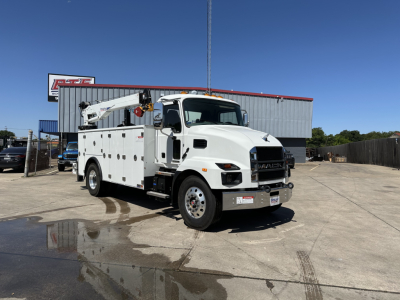Mack MD7 service truck with utility crane and compartments, front three-quarter view in an open lot.