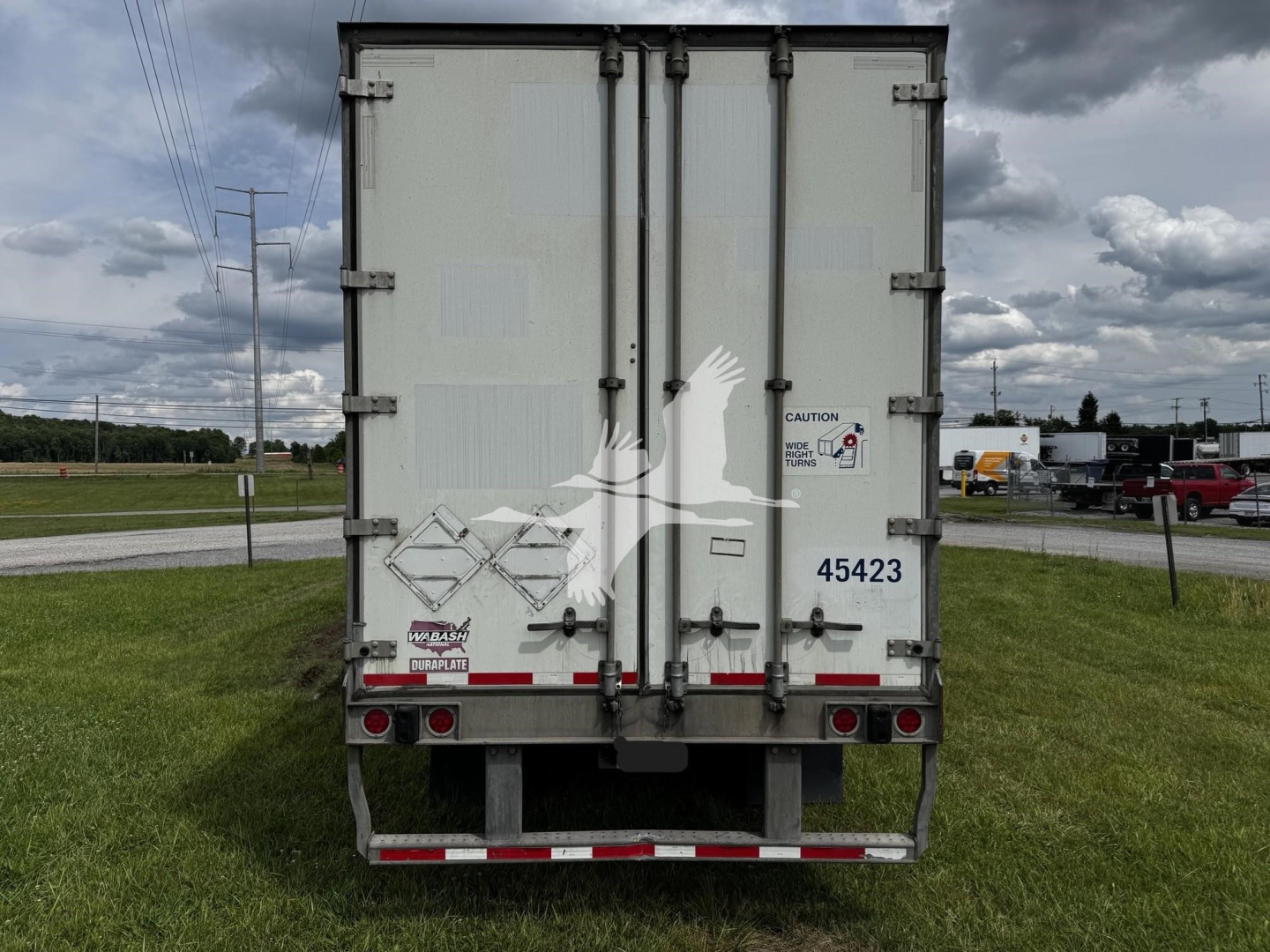 Rear view of a 2017 Wabash van trailer showing double rear doors and various labels and hazard stickers.