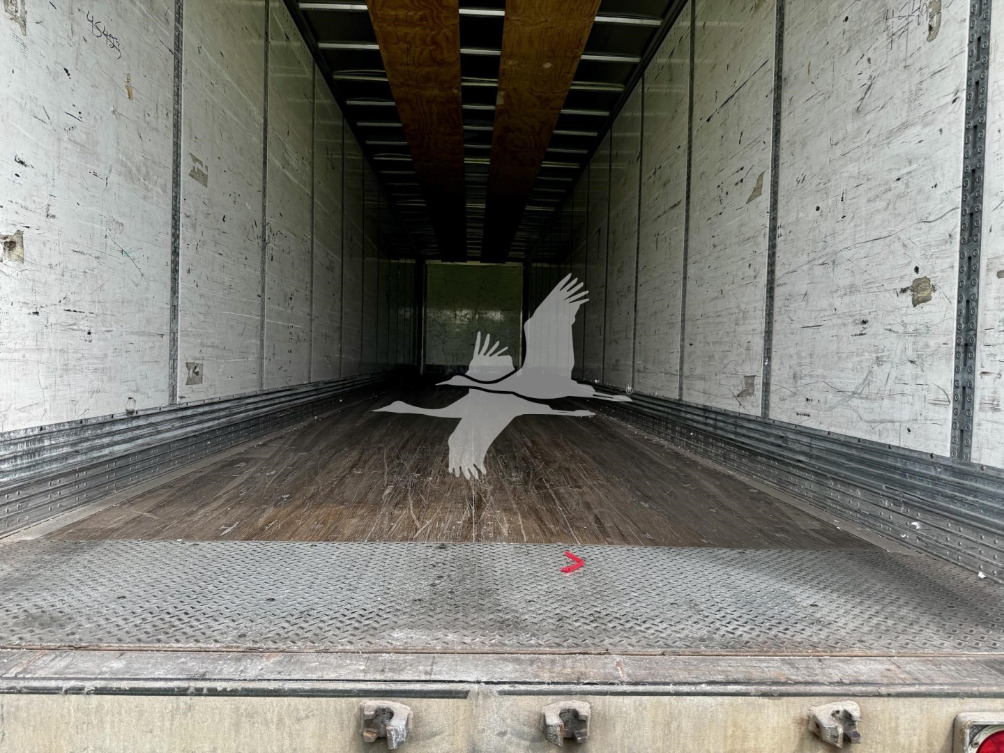 Trailer interior showing wooden floor and metal side walls; empty cargo area in a 2017 Wabash van trailer with stock number 7705.