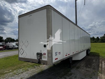 Trailer side view showing a white Wabash trailer with decals and a rear doors; visible text includes ‘53’ on the side and various safety decals near the back. No engine or fluid labels are visible.