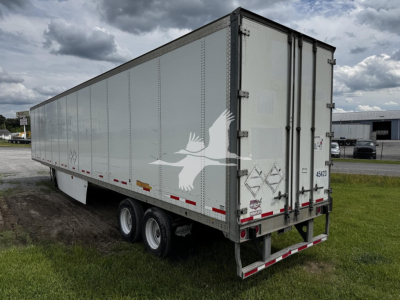 Trailer side view of a 2017 Wabash van trailer, tandem axle, long box with rear doors and reflective strips; stock 7705, VIN 1JJV532D3HL942036.