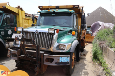Front view of a green 2007 International WorkStar 7400 dump truck with a front bumper guard and mounted light bar.