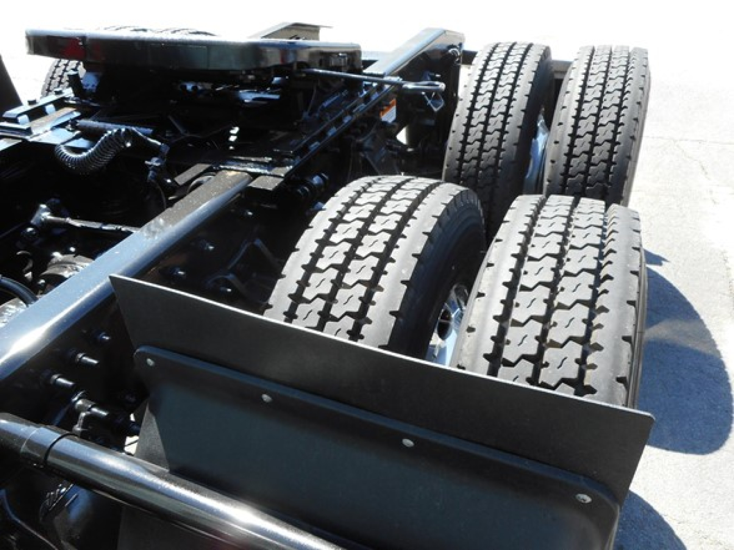 Freightliner Cascadia 126 chassis showing rear dual rear axles and tires with undercarriage components visible.