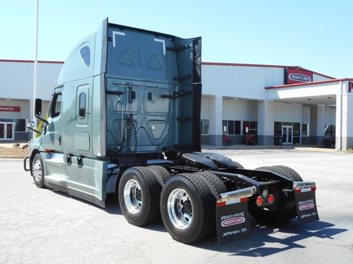 Truck cab and rear view showing fifth wheel and dual rear axles from left rear angle.