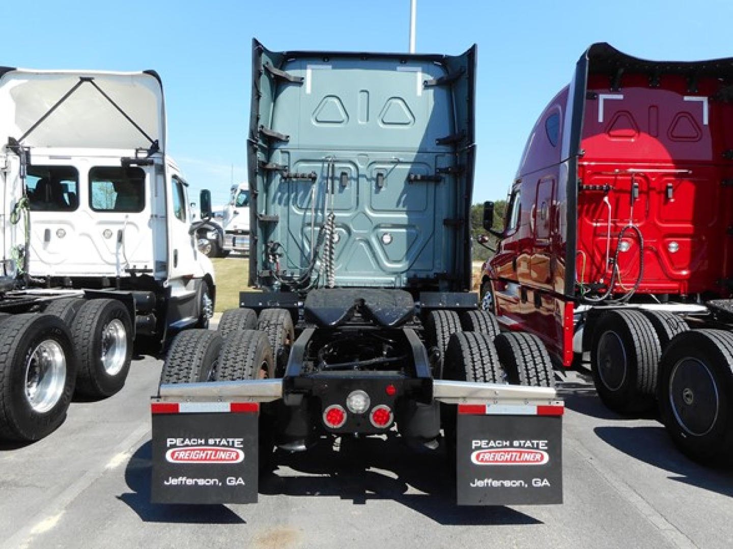 Truck chassis rear view showing trailer connection and mud flaps with Peach State Freightliners Jefferson, GA text.