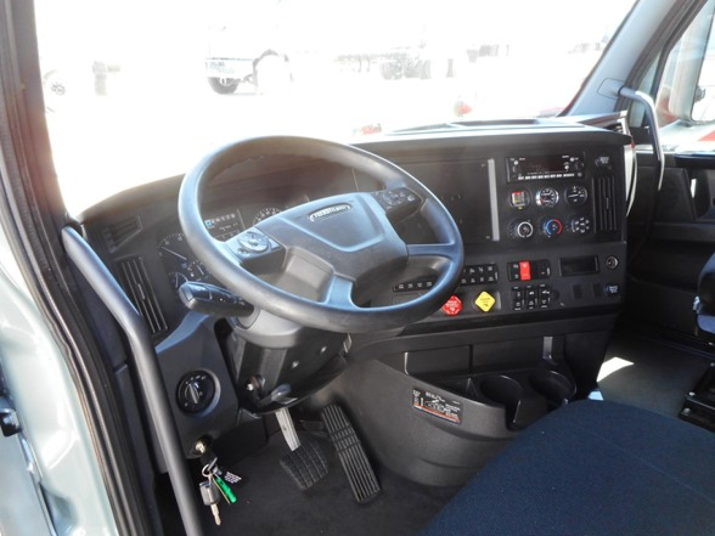 Freightliner Cascadia truck interior driver area with steering wheel and dashboard controls visible