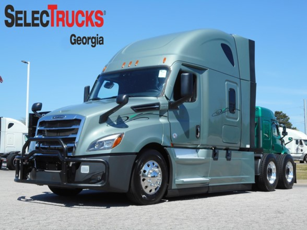 Semi truck cab in profile showing a Freightliner Cascadia 126 with chrome front bumper, aerodynamic mirrors, and sleeper cab. SelecTrucks Georgia watermark visible.