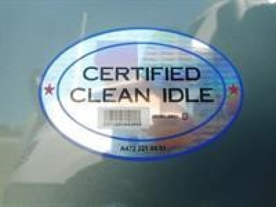 Sticker on Freightliner truck showing CERTIFIED CLEAN IDLE with barcode and holographic design.