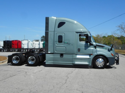 Tractor unit side view showing Freightliner Cascadia 126 sleeper cab with chrome wheels and dual rear axles.