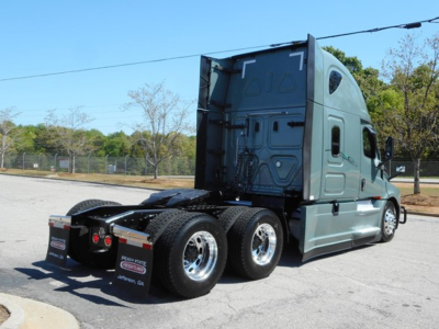 Freightliner Cascadia 126 sleeper tractor with dual rear axles and gray-green cab, rear view showing fifth wheel and rear tires.