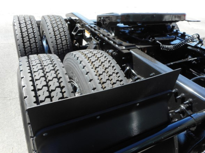 Tractor trailer chassis showing dual rear axles with tires and frame, view of fifth wheel area and suspension components.