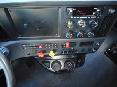Freightliner Cascadia dash view showing instrument cluster, radio, switches, and dual cup holders.