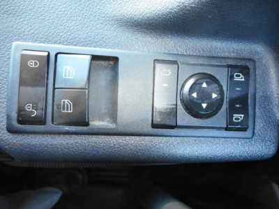Panel of Freightliner Cascadia door control switches including window controls and mirror adjustments.