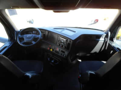 Cab interior of a Freightliner Cascadia 126 truck showing steering wheel, dashboard, and seating from the driver and passenger views.