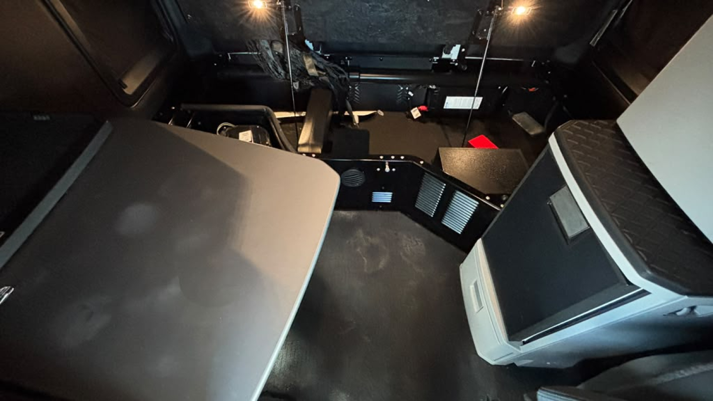 Kenworth T680 interior cab area with sleeper berth and dashboard components visible.